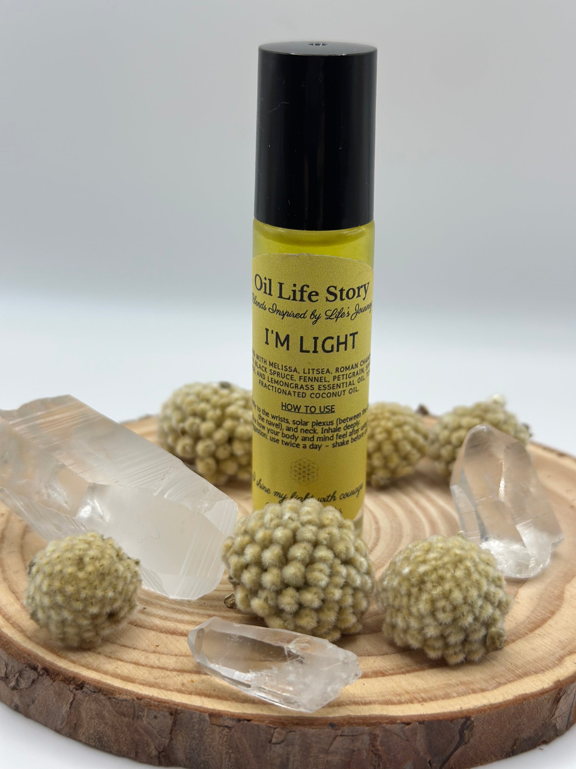 I Am Light essential oil blend with clear quartz and textured botanicals on a wooden plate
